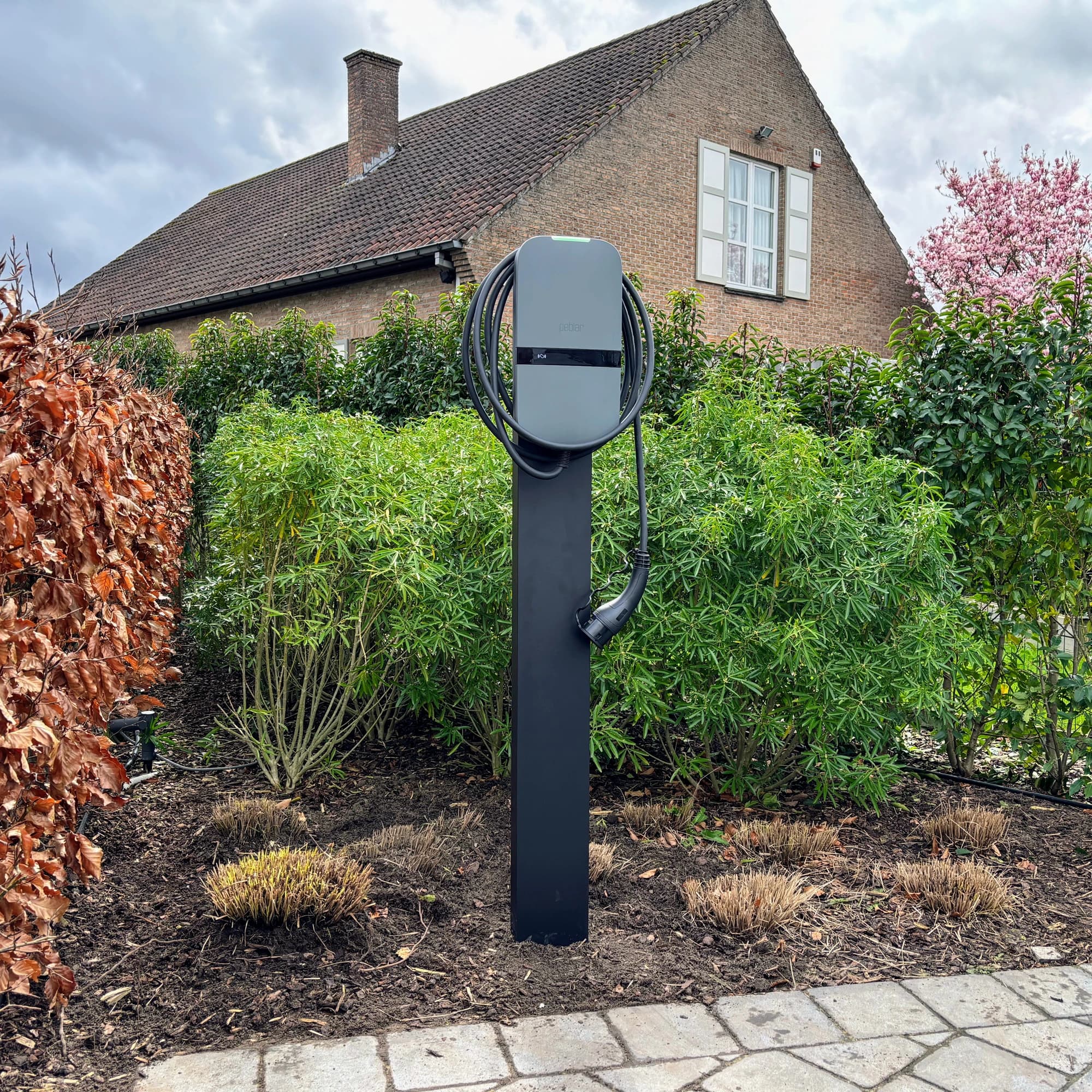 Laadpaal voor een elektrische wagen naast een woning